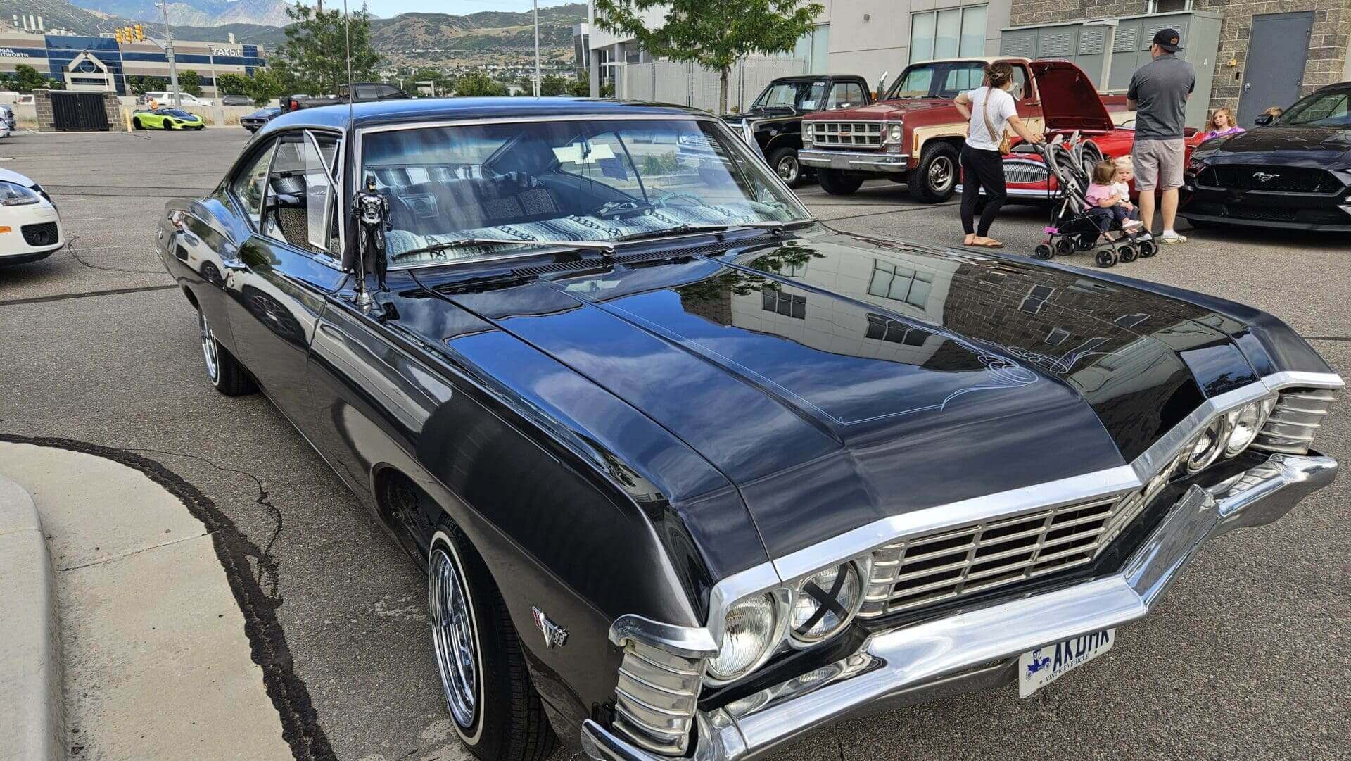 Black classic car parked at outdoor event.